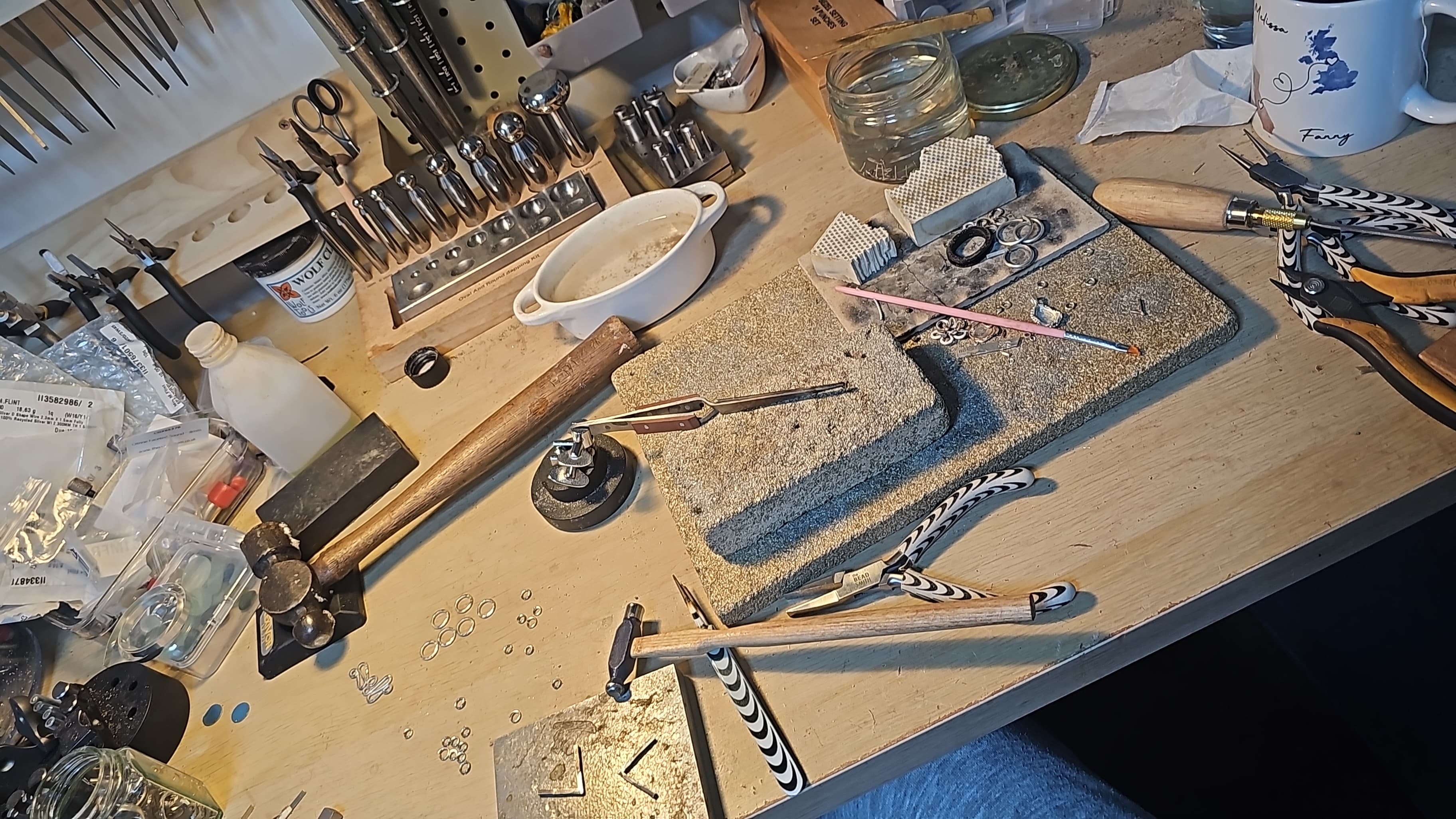 Melissa's jewellery-making workbench covered in tools and materials