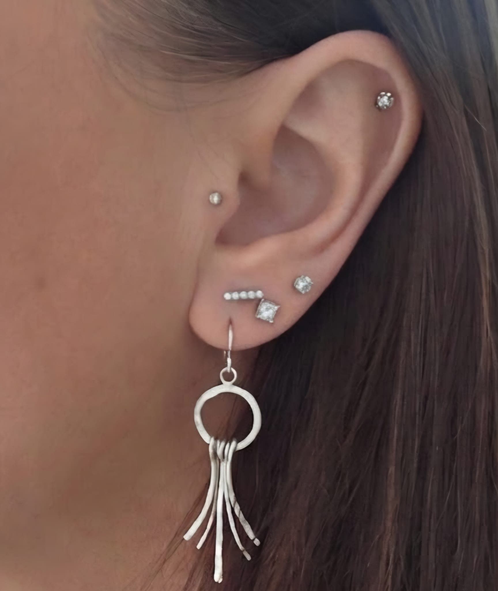 Full ear stack with cartilage stud, lobe bar and stud, and a handmade silver tassel earring